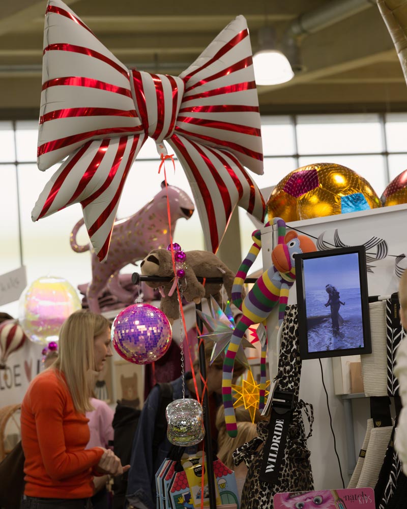 Oversized striped balloon bow above a playful product display