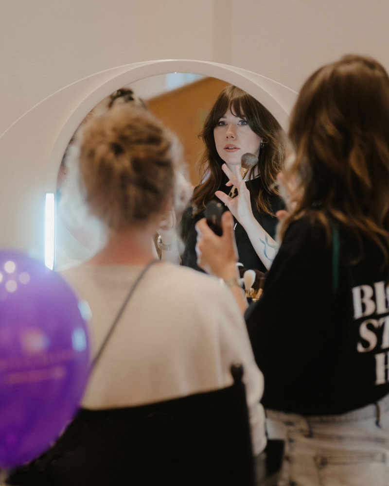 Guest getting a touch-up at the beauty bar mirror