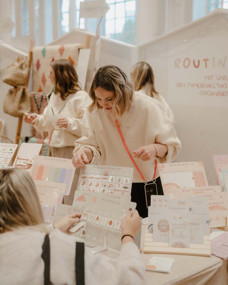 Visitor browsing curated family planner cards at a stand