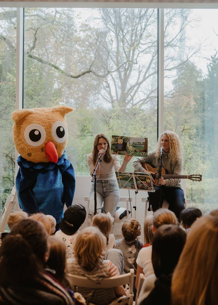 Mascot and musicians performing a children's story on stage