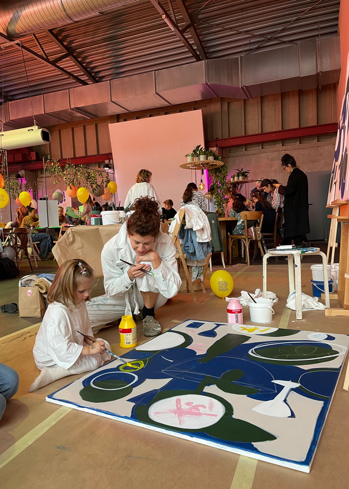 Parent and child painting a large canvas together at a workshop