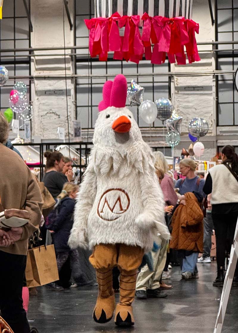 Mascot chicken costume greeting visitors at the event